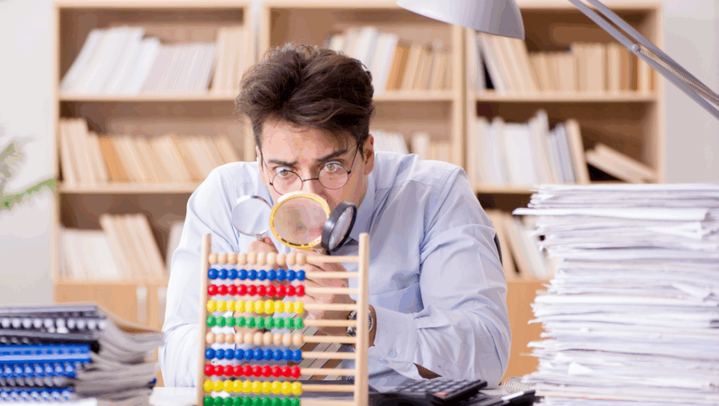 Entrepreneur examinant minutieusement sa comptabilité avec des loupes, cherchant une erreur potentielle dans ses documents.