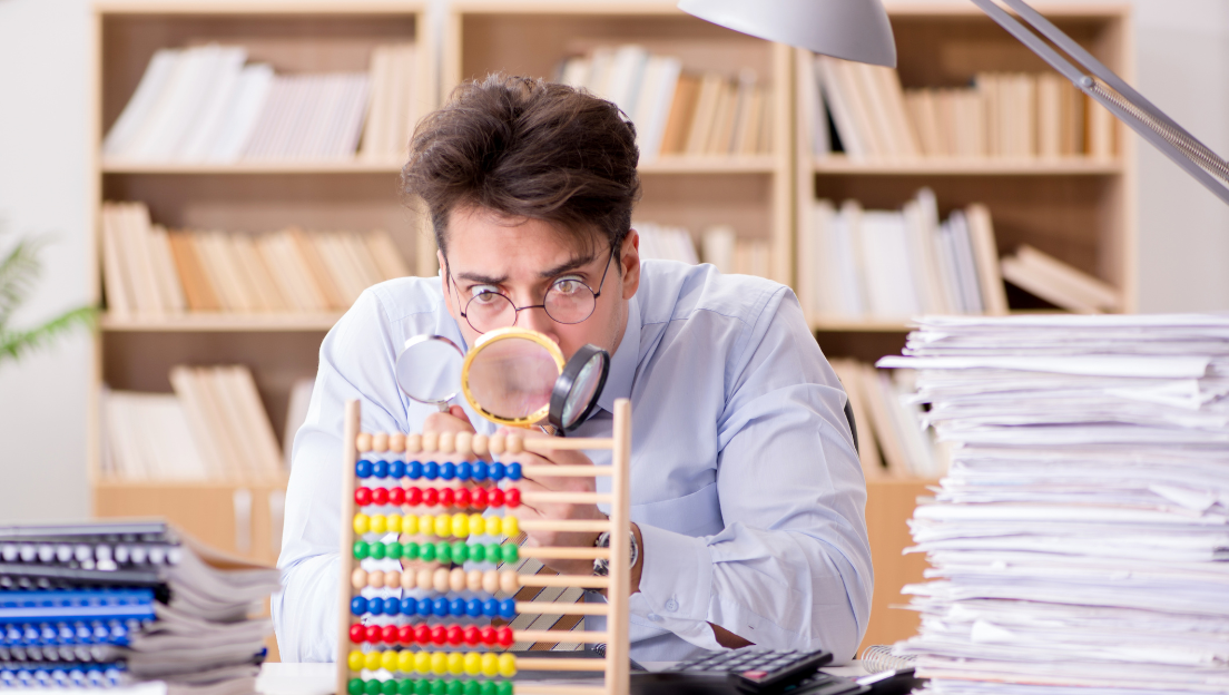 Entrepreneur examinant minutieusement sa comptabilité avec des loupes, cherchant une erreur potentielle dans ses documents.