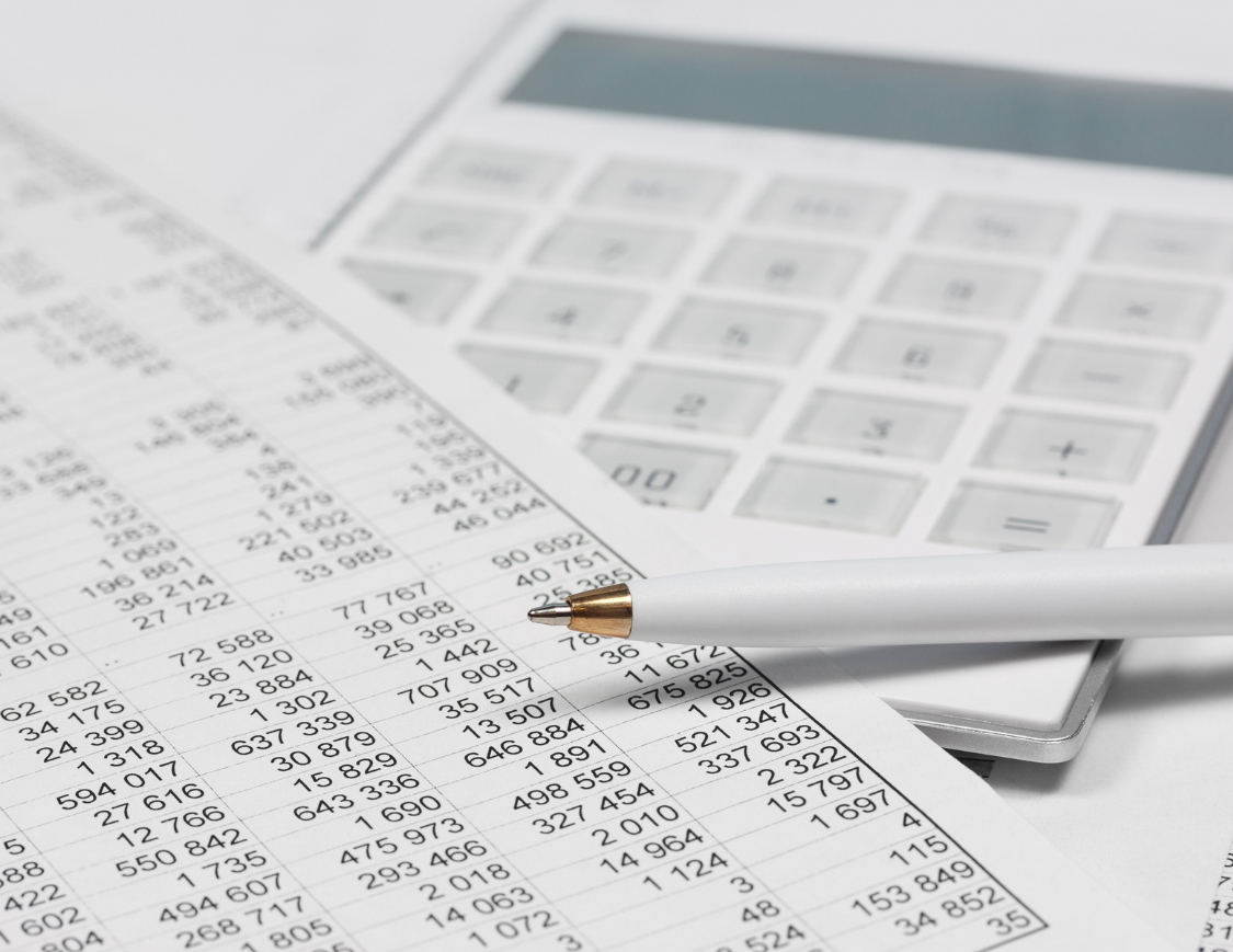 Documents comptables avec tableau de chiffres, calculatrice et stylo, illustrant l’importance de bien conserver ses données financières.